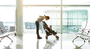 Mulher com carrinho de bebê em aeroporto